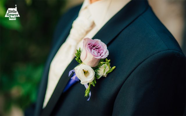 Groom at wedding wearing a pink rose boutonniere