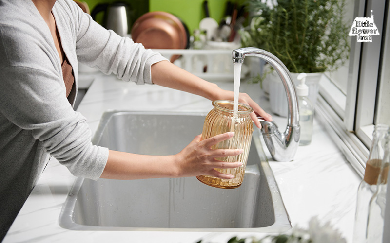 Woman filling a vase with tap water 