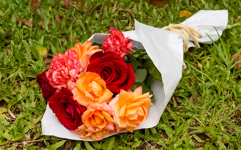 Bouquet of vibrant orange and red roses for graduation.